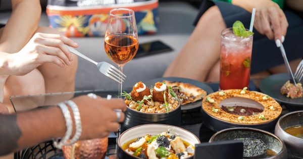 pessoas-compartilhand-comidas-bebidas-em-mesa-de-restaurante